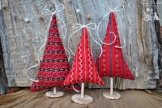 three red and black christmas trees on wooden stand