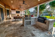 an outdoor kitchen with grill and seating area