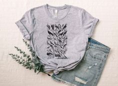 a t - shirt with an image of flowers on it and some denim shorts next to it