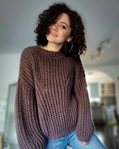 a woman wearing a sweater and jeans posing for the camera