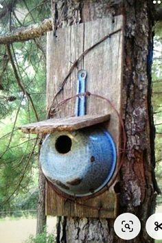 a blue birdhouse hanging from a tree