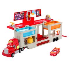 a toy firetruck with a sink and car on the back is next to a play set