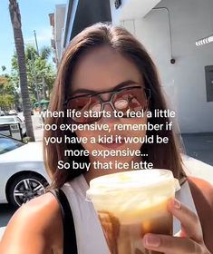 a woman holding a drink in her right hand and looking at the camera with a caption that reads, when life starts to feel a little too expensive, remember if you have a kid