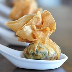 a close up of food on a spoon with other foods in the backgroud