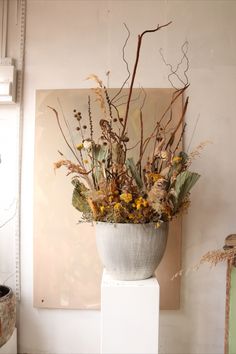 a white vase filled with lots of different types of flowers