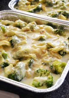 two pans filled with broccoli and cheese covered casserole on top of a counter