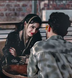 a woman sitting next to a man on a bench