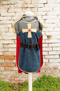 a dress made to look like a knight with a cross on the chest and red cape