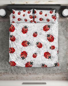 a bed with red ladybugs and white flowers on it