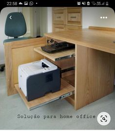 an office desk with a printer on it and a chair in the corner behind it