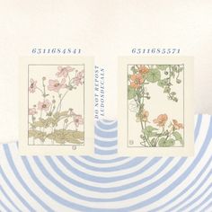 two postage stamps with flowers on them sitting on top of a blue and white striped plate