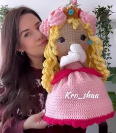 a woman holding a crocheted doll in front of her face with the words ko - shaa written on it