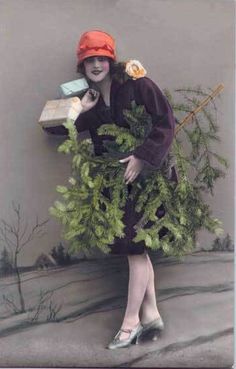 a woman in an orange hat and dress is holding a box full of green plants