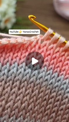 the video is showing how to crochet with yarn in two different colors, including pink and gray