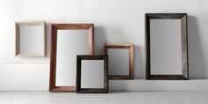 three wooden frames sitting next to each other on a white wall with one empty frame