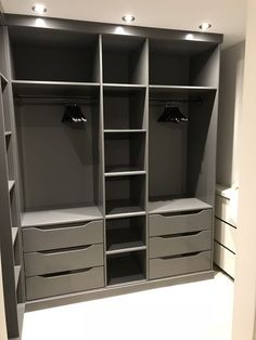 an empty walk in closet with drawers and lights