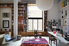 a living room filled with lots of furniture and bookshelves