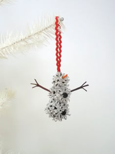 a snowman ornament hanging from a christmas tree