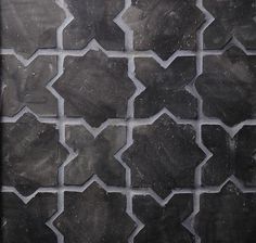 a black and white tiled wall with an interesting pattern on the bottom part of it