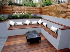 a wooden bench sitting on top of a hard wood floor next to a wall covered in plants