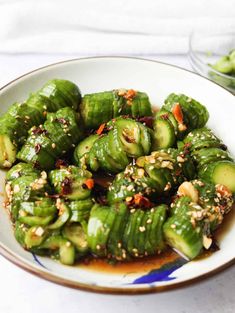 a white plate topped with green vegetables covered in sauce