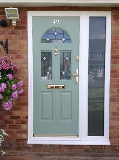 a green front door with glass and flowers