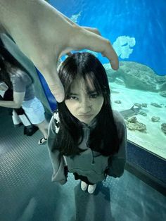 a woman standing in front of an aquarium