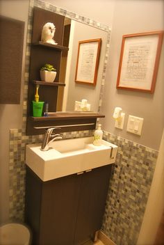 a bathroom sink sitting under a mirror next to a toilet