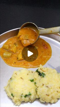 a metal plate topped with food next to a bowl of rice and sauce on top of it