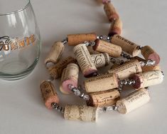 there is a wine glass and some corks on the table next to each other