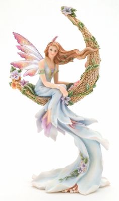 a figurine of a woman holding a bird on top of her arm and flying through the air