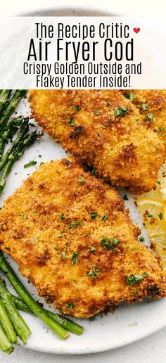 two pieces of fried chicken on a plate with asparagus