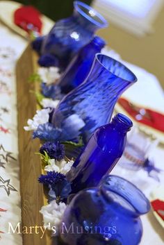 blue glass vases are lined up on a table