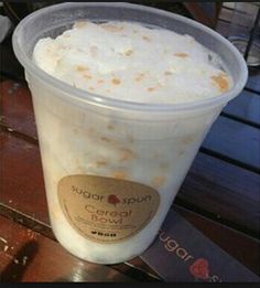 a plastic cup filled with ice cream on top of a wooden table