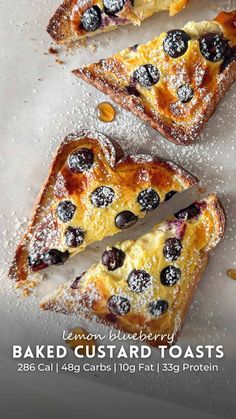 baked custard toasts with blueberries and powdered sugar are on display