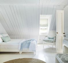 a bedroom with white walls and wooden furniture