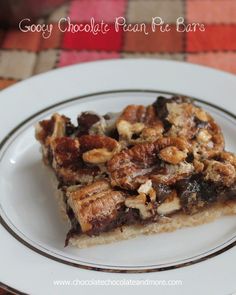 a slice of gooey chocolate pecan pie bars on a white plate with black and silver trim