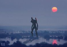 a man standing on top of a hill with the sun in the background