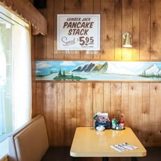 there is a painting on the wall behind the table in this diner's booth