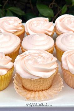 cupcakes with white frosting sitting on a plate