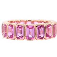 a pink tourmaline ring with four rows of stones in the center and two rows of diamonds on each side