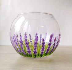 a glass bowl with purple flowers painted on the inside and green stems in the outside