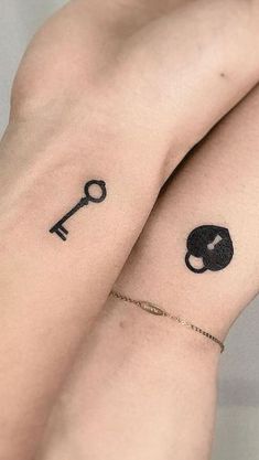 two people with tattoos on their arms, one has a key and the other has a heart