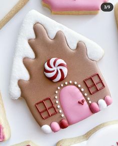 a gingerbread house decorated with pink and white icing