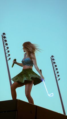 a woman holding an umbrella standing on top of a roof