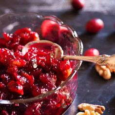 a glass bowl filled with cranberry sauce next to walnuts and other ingredients