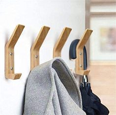 three coat hooks are hanging on the wall