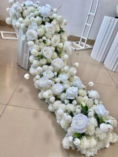 white flowers are arranged in the shape of an arrow on the floor next to chairs