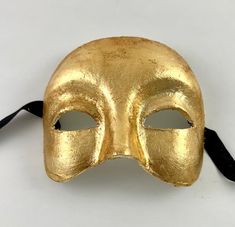 This Venetian half mask is perfect for any masquerade event.  Simple yet elegant.  The mask is handmade from paper mache and then decorated in gold leaf. The mask's dimensions are approximately 6" wide, 5" high and 3 ½" deep. All masks are handmade in Venice, Italy.  No two masks are ever identical. Venetian Gold Mask For Party, Gold Venetian Mask For Halloween, Gold Venetian Mask, Luxury Gold Venetian Masquerade Mask, Gold Baroque Mask For Carnival, Venetian Masquerade Masks, Half Face Mask, Venetian Masquerade, Half Mask