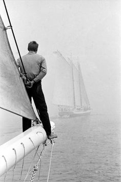 a man standing on the side of a sail boat